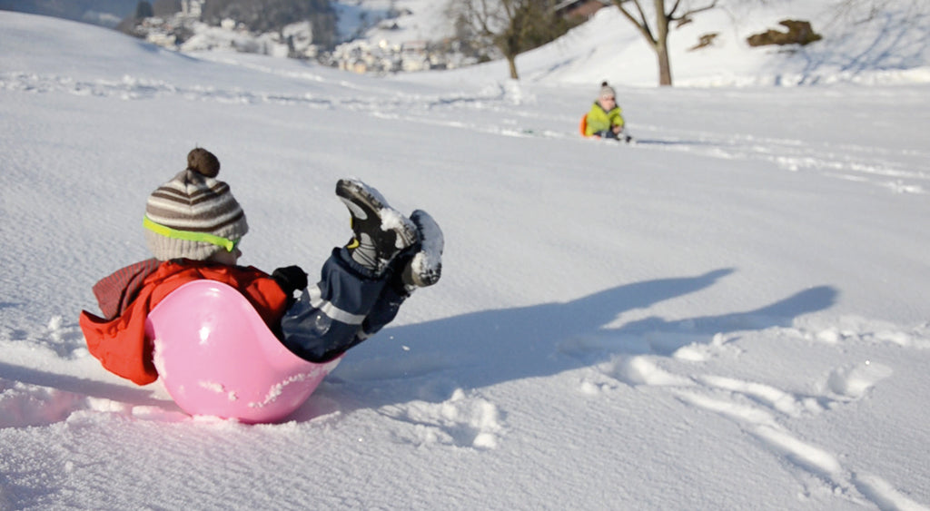 kind speelt met roze Bilibo in de sneeuw