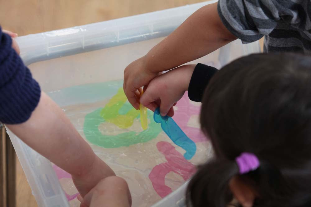 kinderen spelen met de silishapes alfabet letters in water