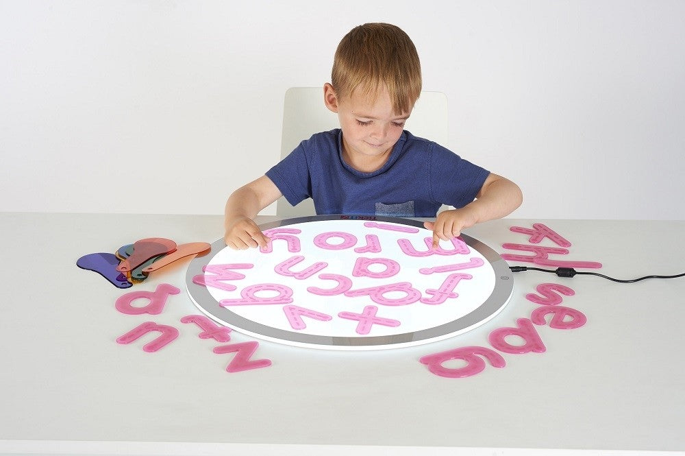 kind speelt met de silishapes alfabetletters op een lichtpaneel