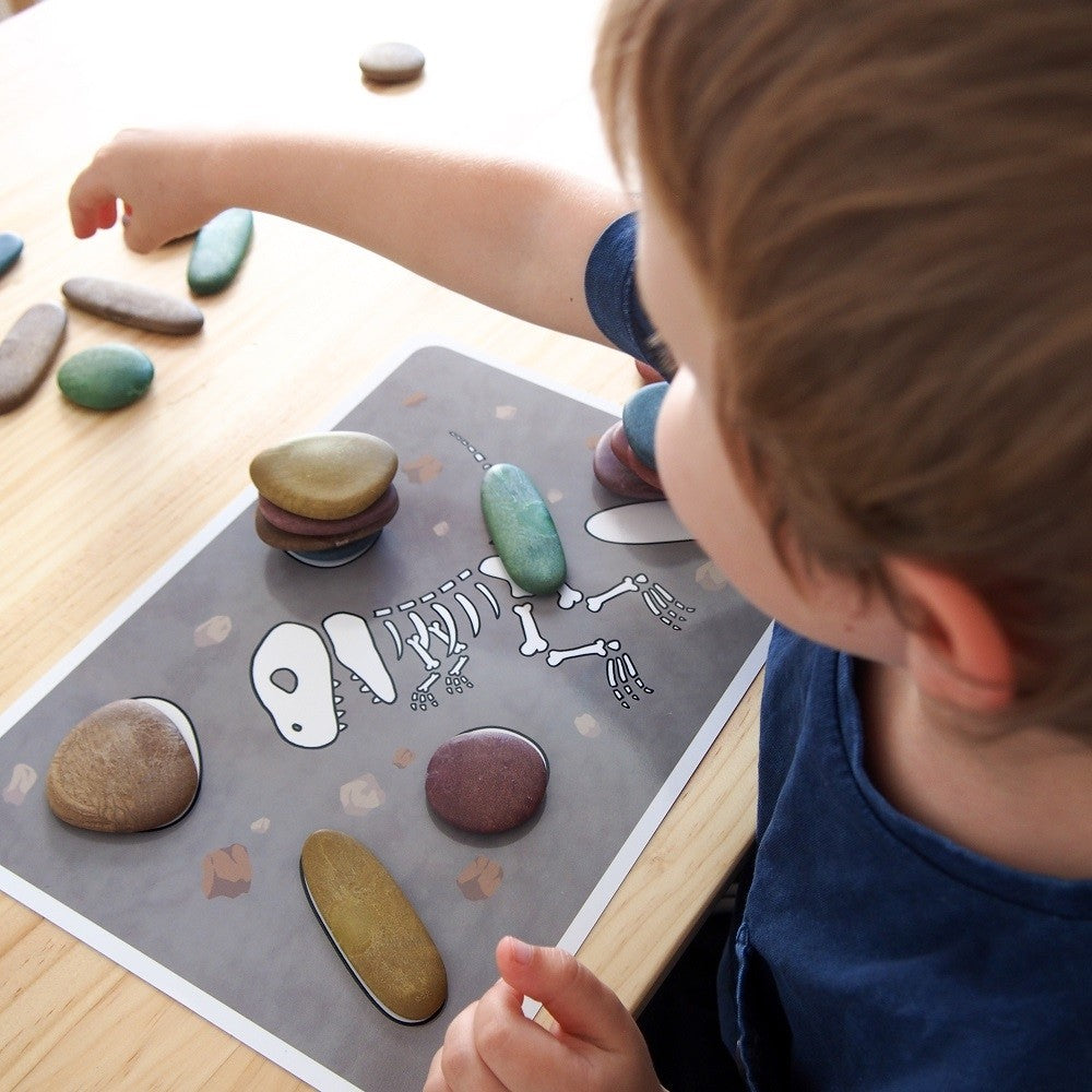 kind speelt met de ecologische pebbles op een activiteitenkaart