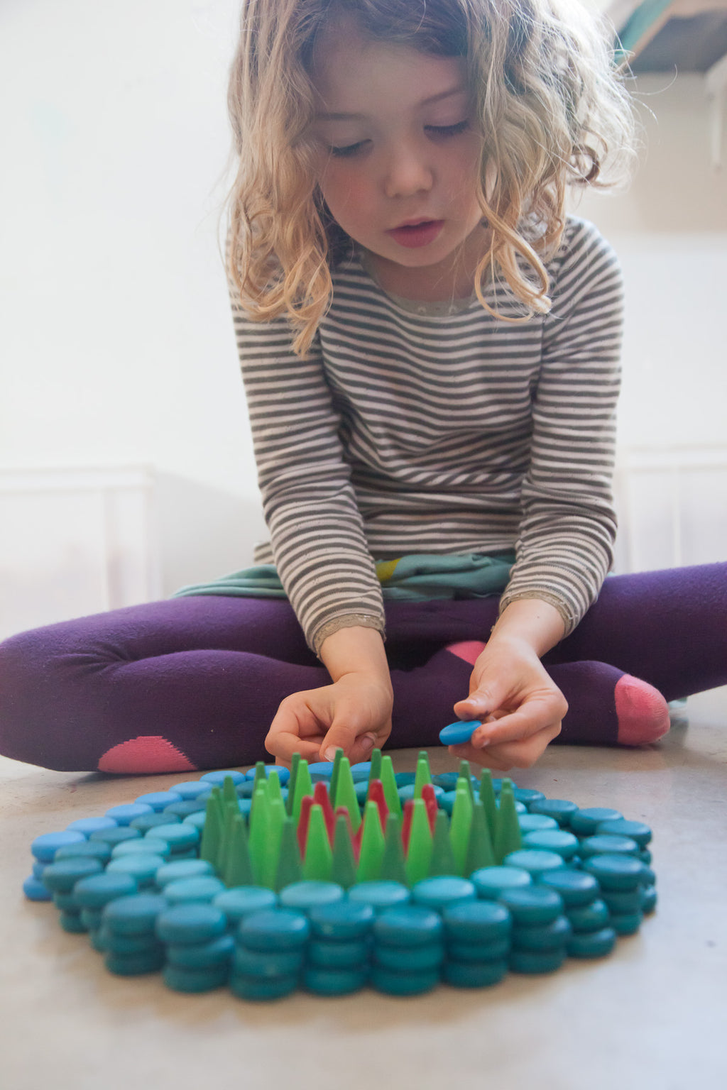 kind maakt houten mandala