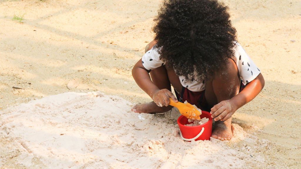 kind speelt op het strand met PlanToys zand speelset