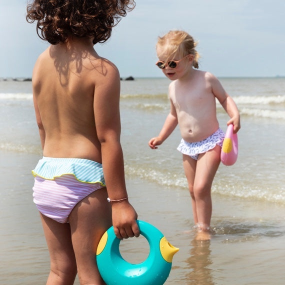 kinderen spelen op het strand met quut strandspeelgoed
