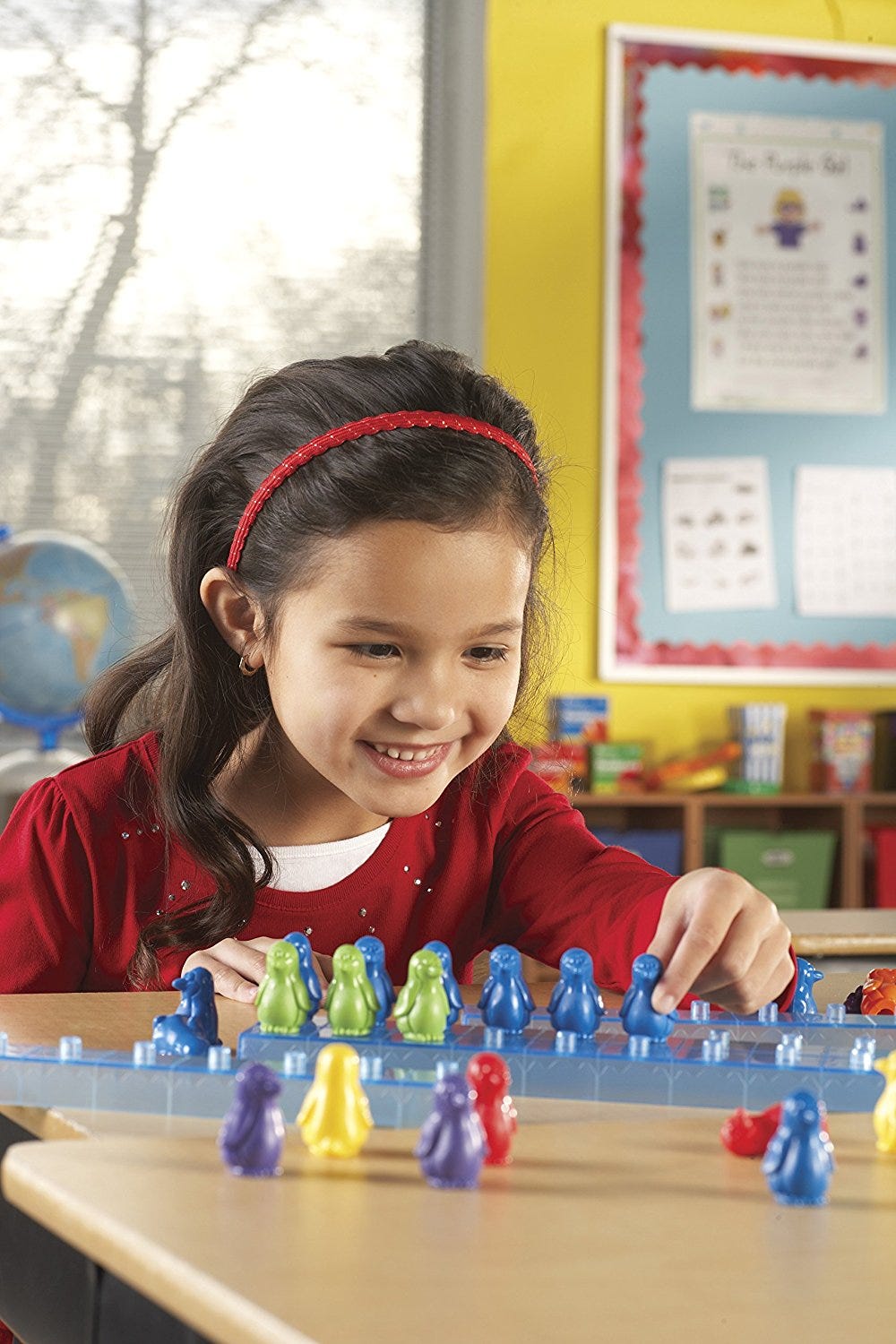 meisje speelt met Learning Resources rekenactiviteiten met pinguins op ijs